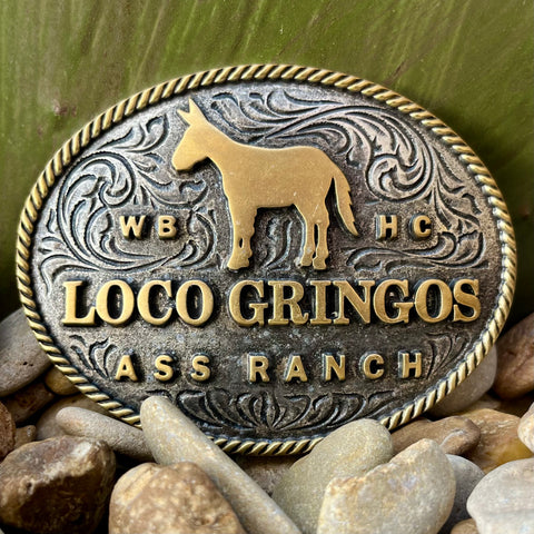 Montana Silversmiths Buckle Loco Gringos in gold and silver tones, features bold engravings and a central donkey motif - A1030WR. Available at Blair's Western Wear, Marble Falls, TX.